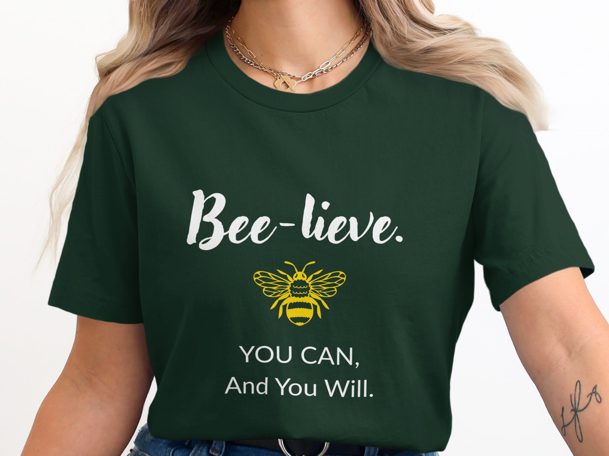 Dark green t-shirt with "Bee-lieve. You can, and you will." text and bee graphic.