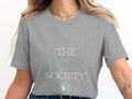 Grey t-shirt with "THE GLUE & GLITTER SOCIETY" text and a star accent.