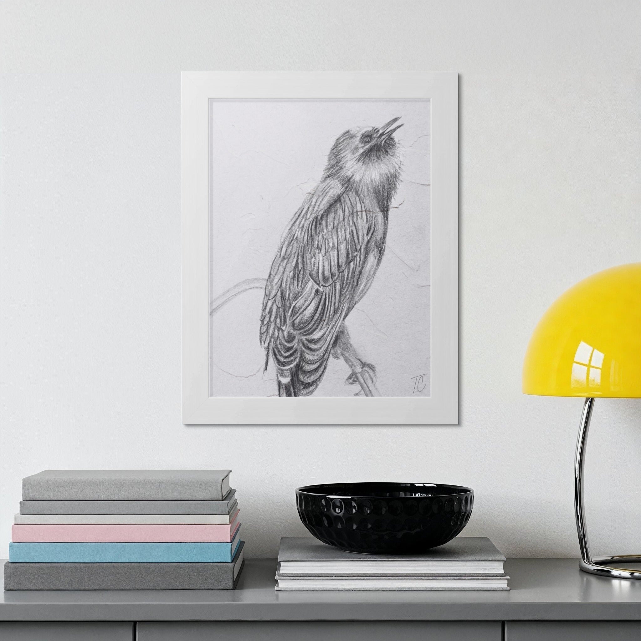 Pencil drawing of a bird perched on a branch, framed on a wall.